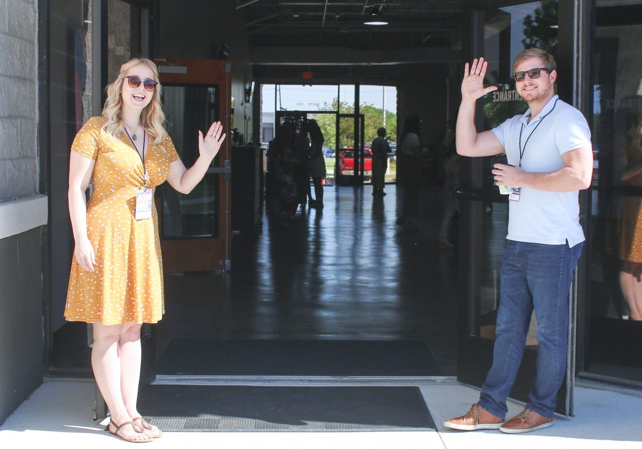 two man and woman standing on doorway